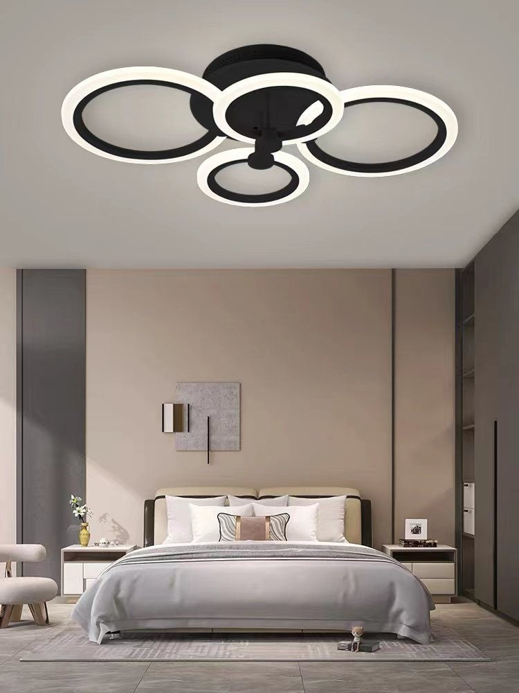 Plafoniera LED cu 4 cercuri negre, design asimetric modern, montata pe tavan deasupra patului dublu