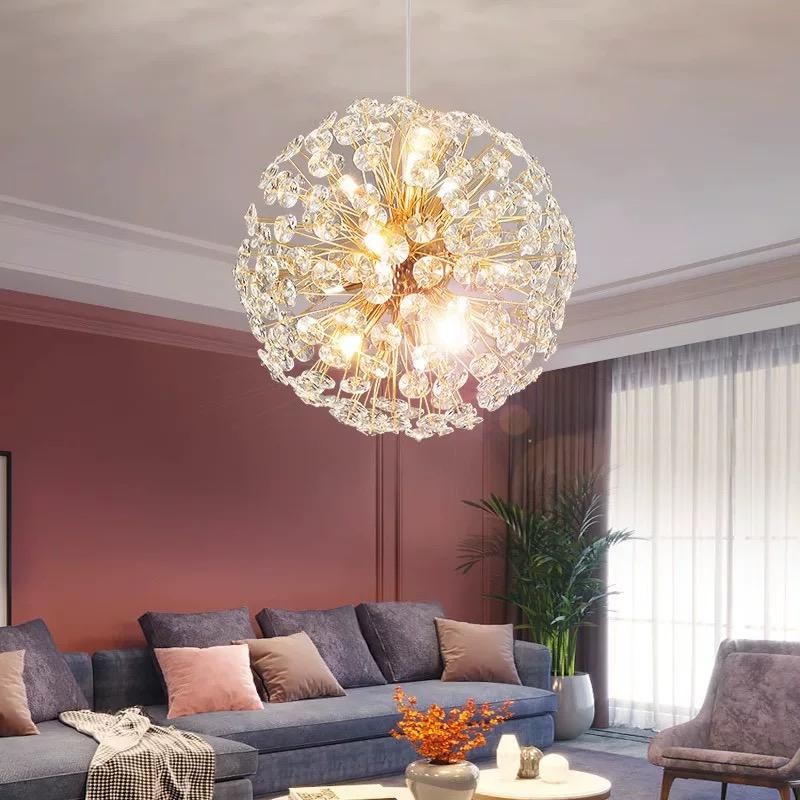 Candelabru glob cristal montat in living modern, structura sferica aurie iluminata deasupra canapelei
