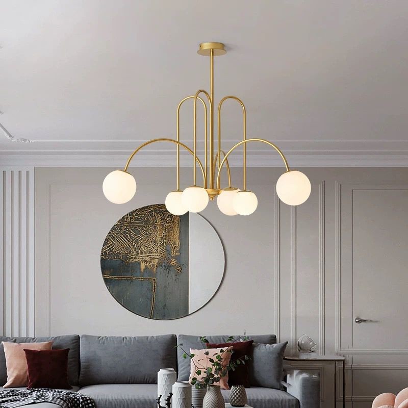 Candelabru auriu cu globuri albe mat montat in living modern, aspect decorativ elegant
