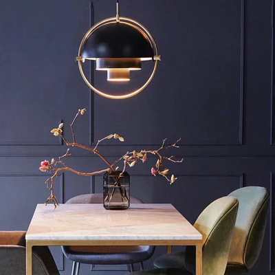 Lustra suspendata negru-auriu montata deasupra mesei de dining, aspect elegnat in interior contemporan
