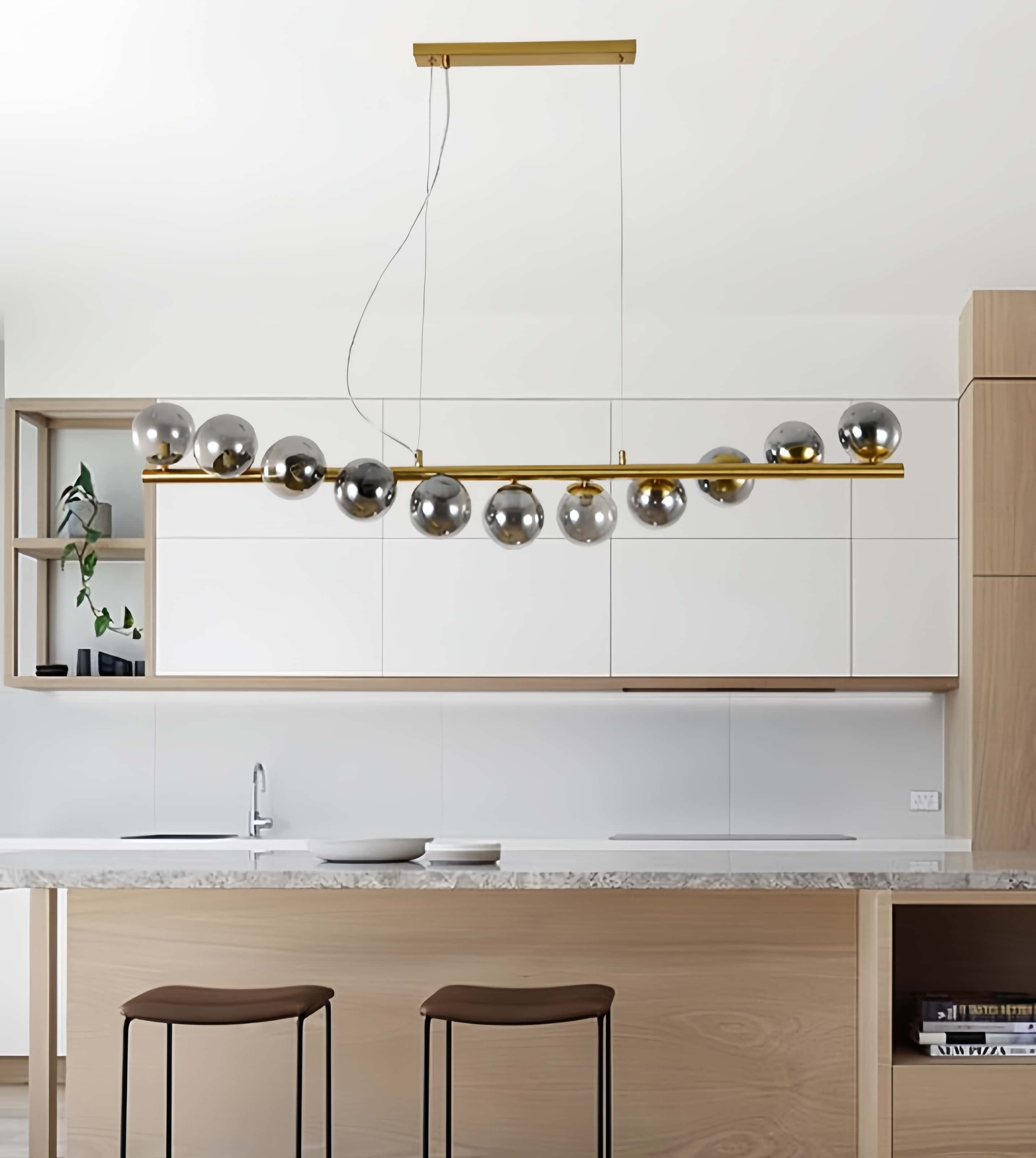 Lustra liniara cu globuri fumurii montata deasupra blatului de bucatarie, aspect elegent auriu