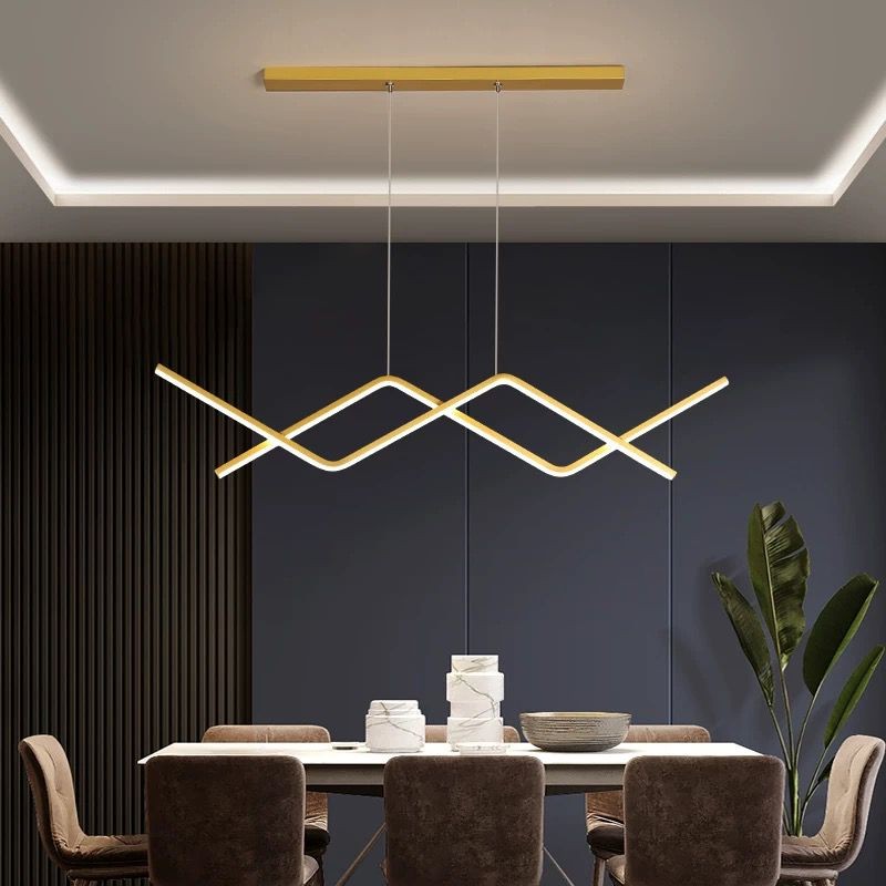 Candelabru LED modern auriu cu design in val, montat pe tavan deasupra unei mese de sufragerie