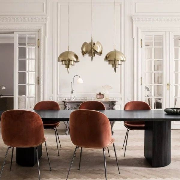 Lustre suspendate aurii deasupra mesei de sufragerie, atmosfera eleganta in interior clasic