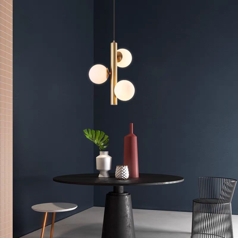 Lustra suspendata cu globuri sticla alba deasupra mesei de dining, design mid-century modern
