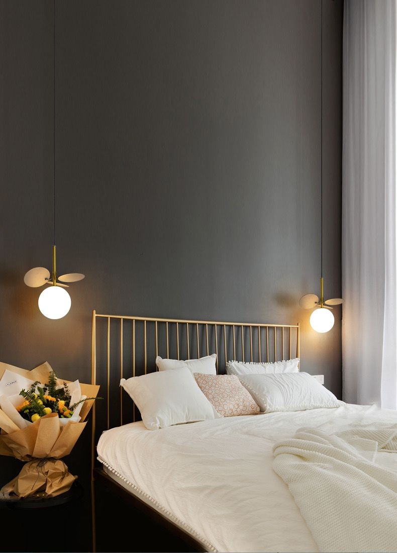 Doua lustre cu glob mat suspendate simetric deasupra patului, atmosfera calda in dormitor modern