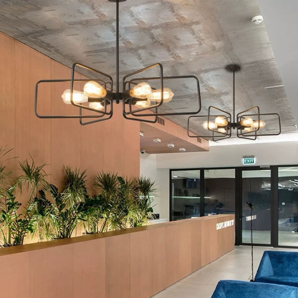 Lustra cu brate rectangulare montata in spatiu comercial cu tavan inalt, aspect industrial in receptie