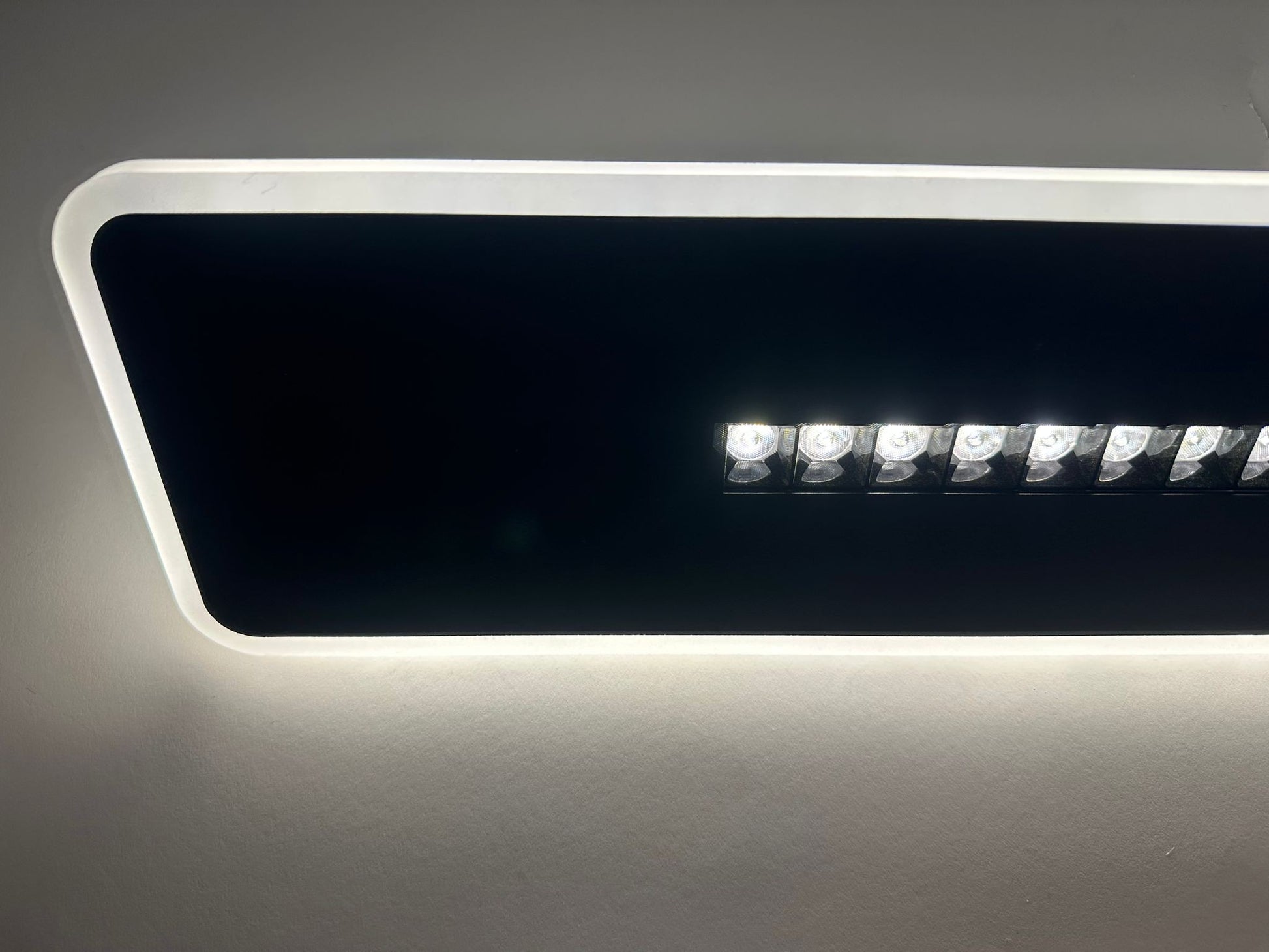 Aplica LED dreptunghi neagra, detaliu spoturi centrale si iluminare de contur difuza pe margini