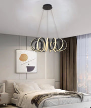 Lustra LED suspendata 62W cu inele rasucite, lumina reglabila 3000K-6500K, montata deasupra patului intr-un dormitor modern