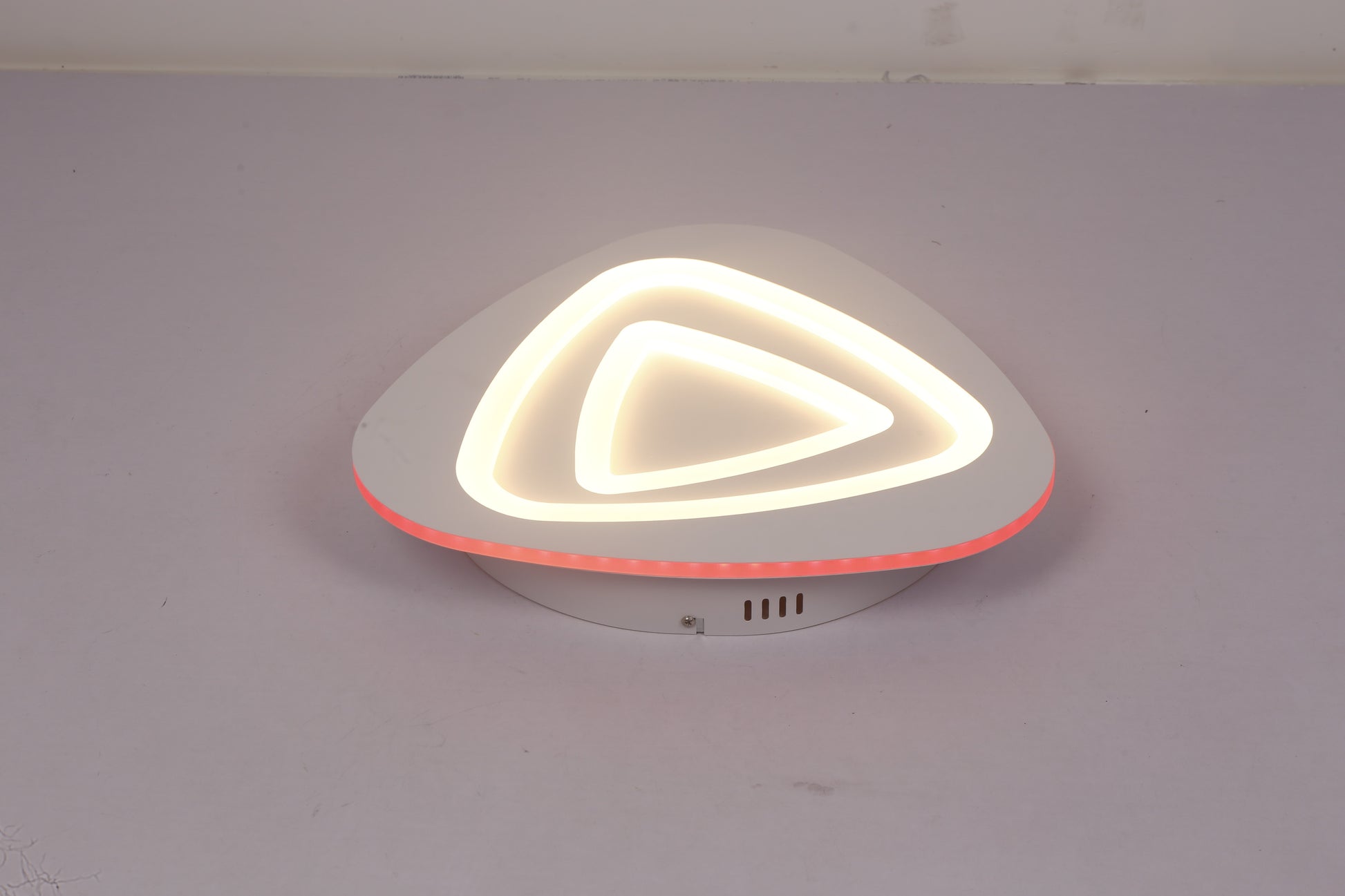 Plafoniera LED triunghi aprinsa cu contur RGB rosu, lumina calda pe straturile acrilice