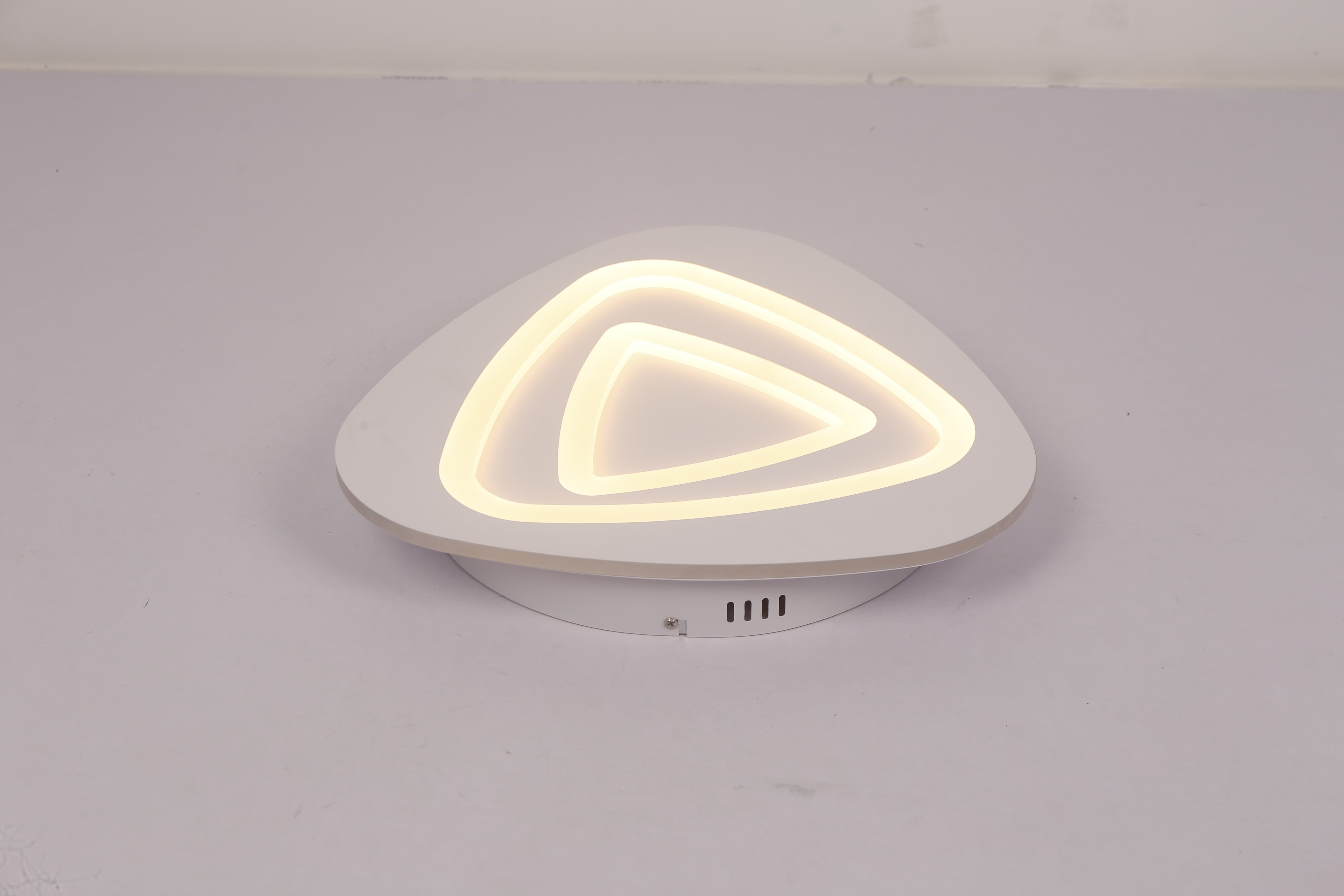 Plafoniera LED triunghi cu lumina calda galbena, intensitate medie, corp alb pe fond gri