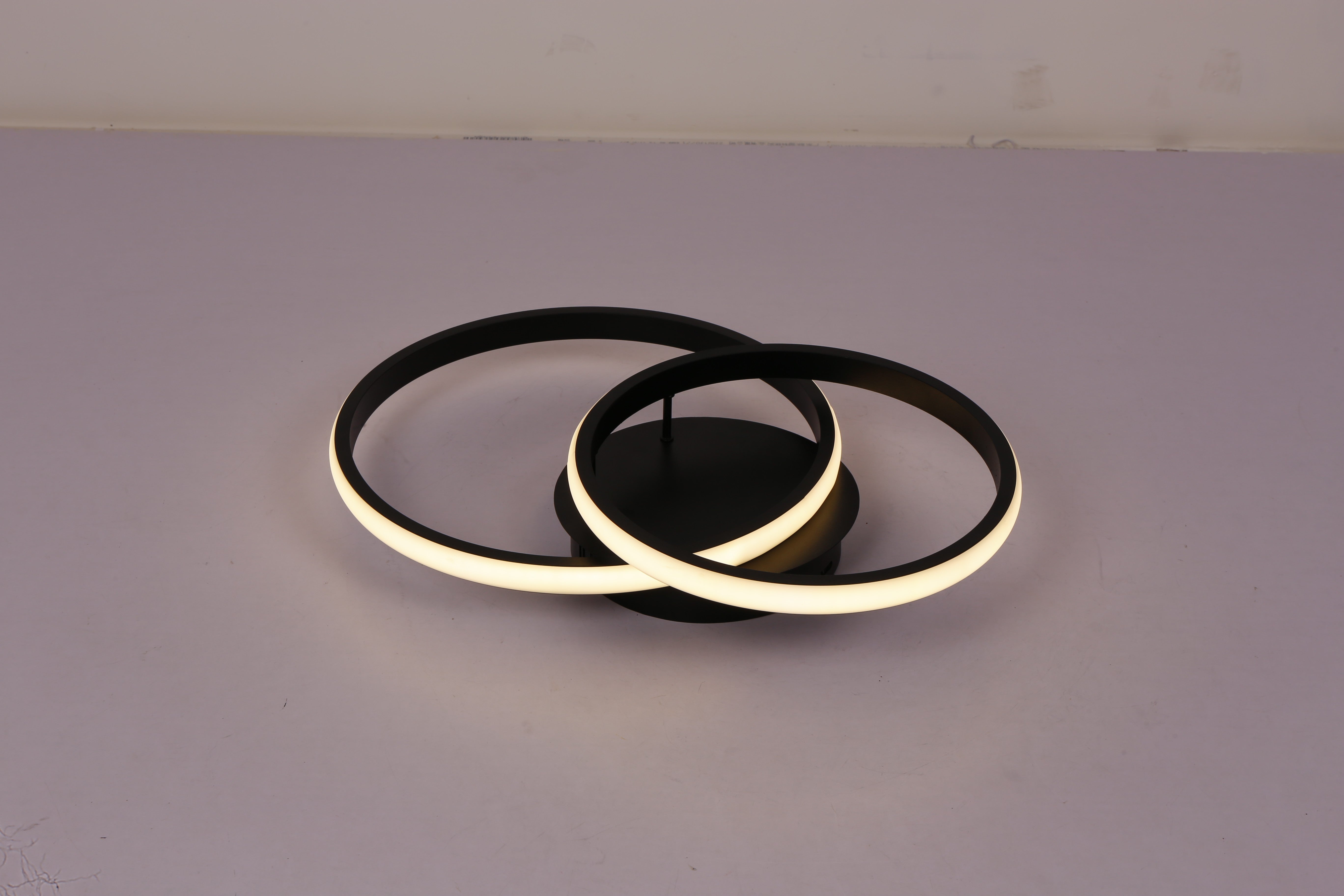 Plafoniera LED doua inele negre aprinsa lumina calda 3000K, vedere laterala pe fond gri