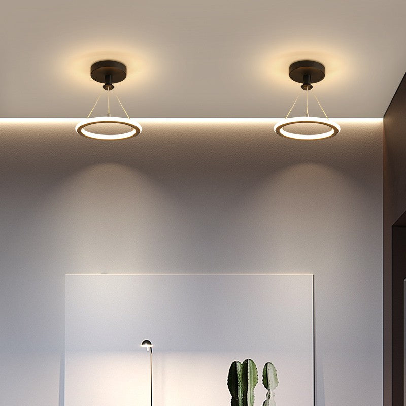 Lustra LED inel negru suspendata prin fire metalice, iluminare uniforma calda, vedere din hol modern