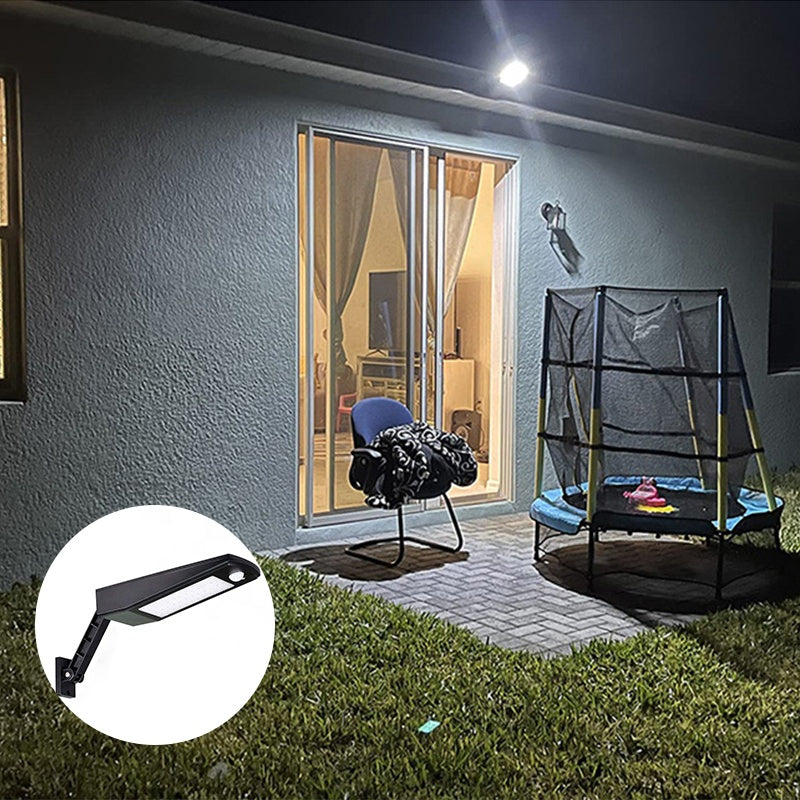 Lampa solara cu senzor de miscare montata pe perete exterior, iluminat curte rezidentiala noaptea